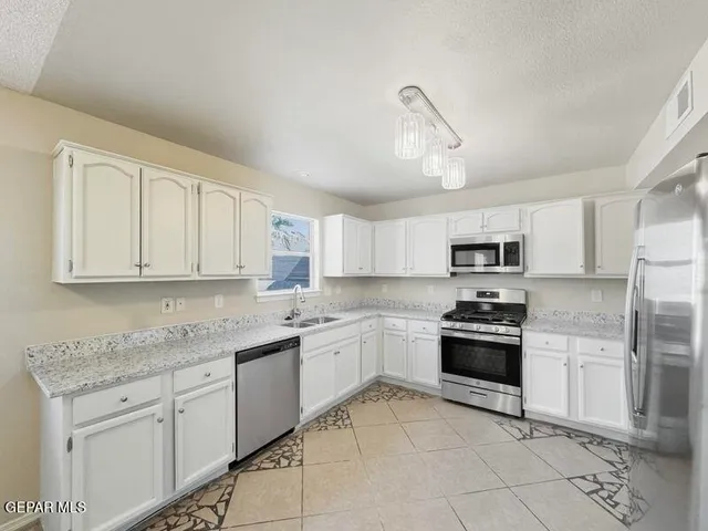 a kitchen with stainless steel appliances granite countertop a stove sink and cabinets
