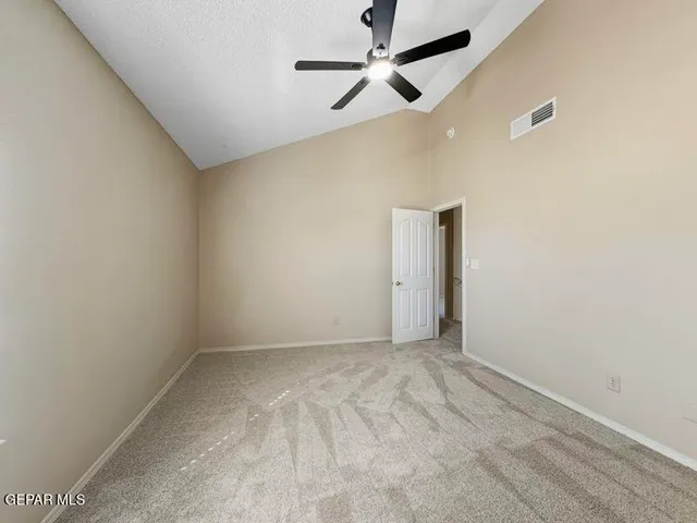 an empty room with a ceiling fan and a window