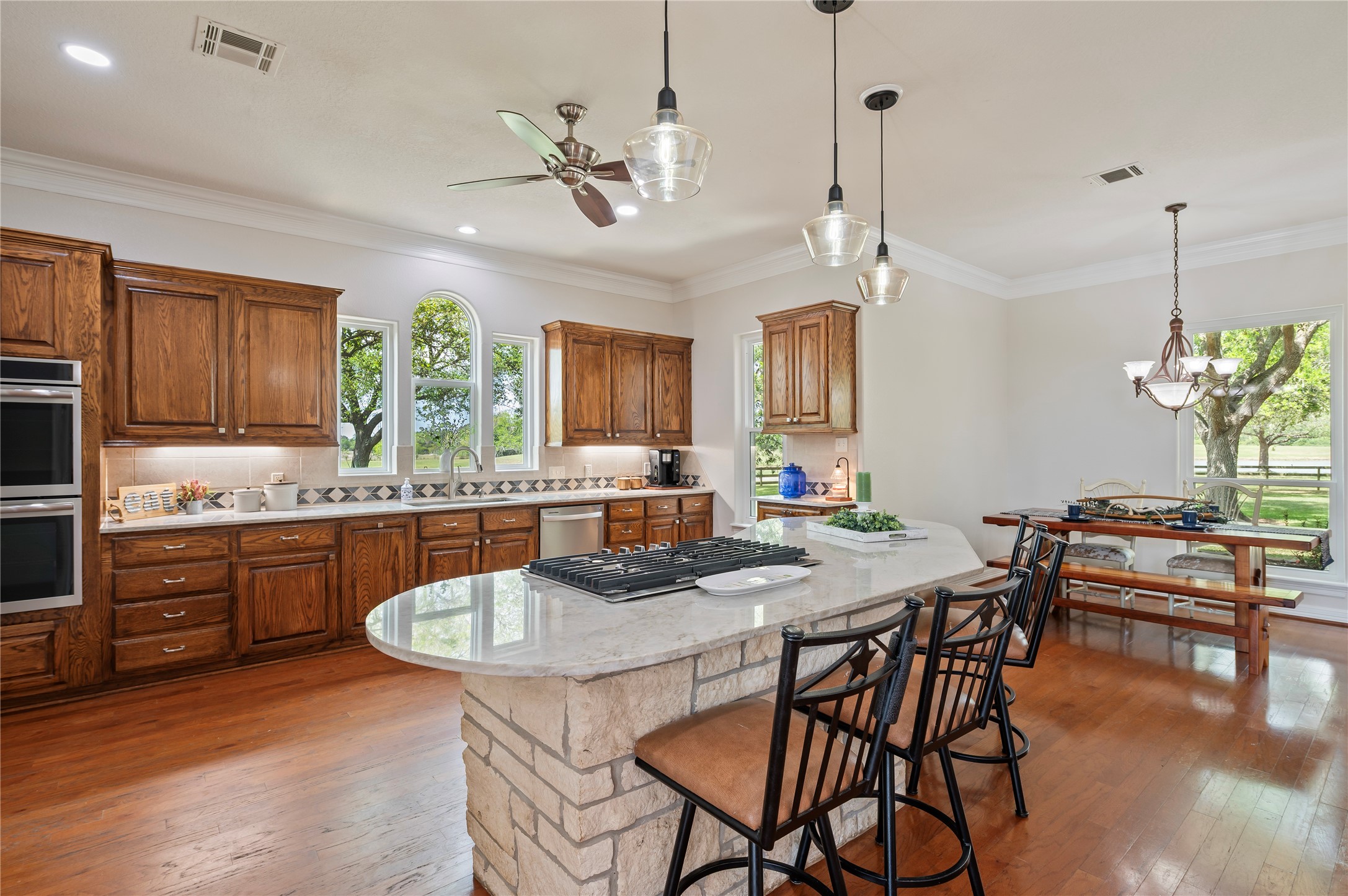 8211 Deats Lane Dickinson, TX 77539 - Photo 23 of 50 a kitchen with granite countertop a table chairs stove and microwave