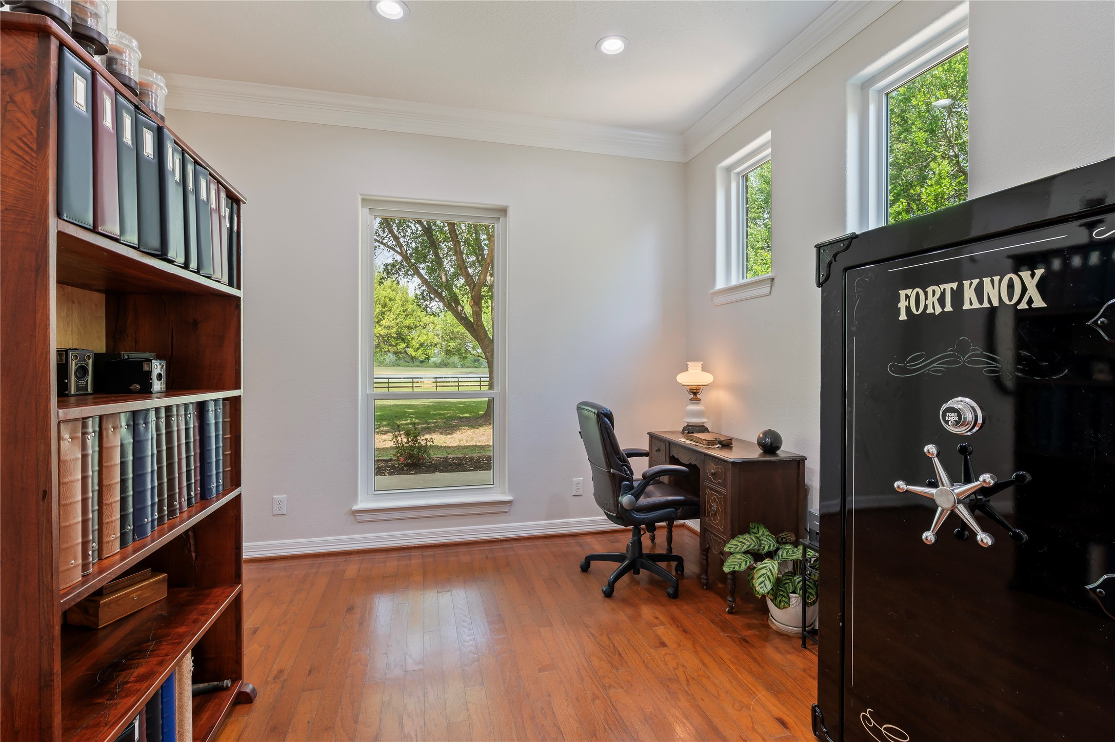 8211 Deats Lane Dickinson, TX 77539 - Photo 28 of 50 Downstairs office with Fort Knox Gunsafe, high ceilings, hardwood floors, fresh paint, crown molding, recessed canned lights and front yard views.