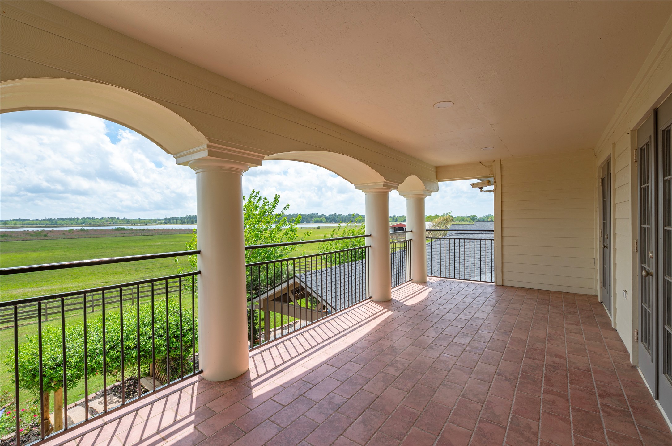 8211 Deats Lane Dickinson, TX 77539 - Photo 35 of 50 The exterior balcony is designed to capture breathtaking views of the property, adorned with ceramic tile flooring and columns.