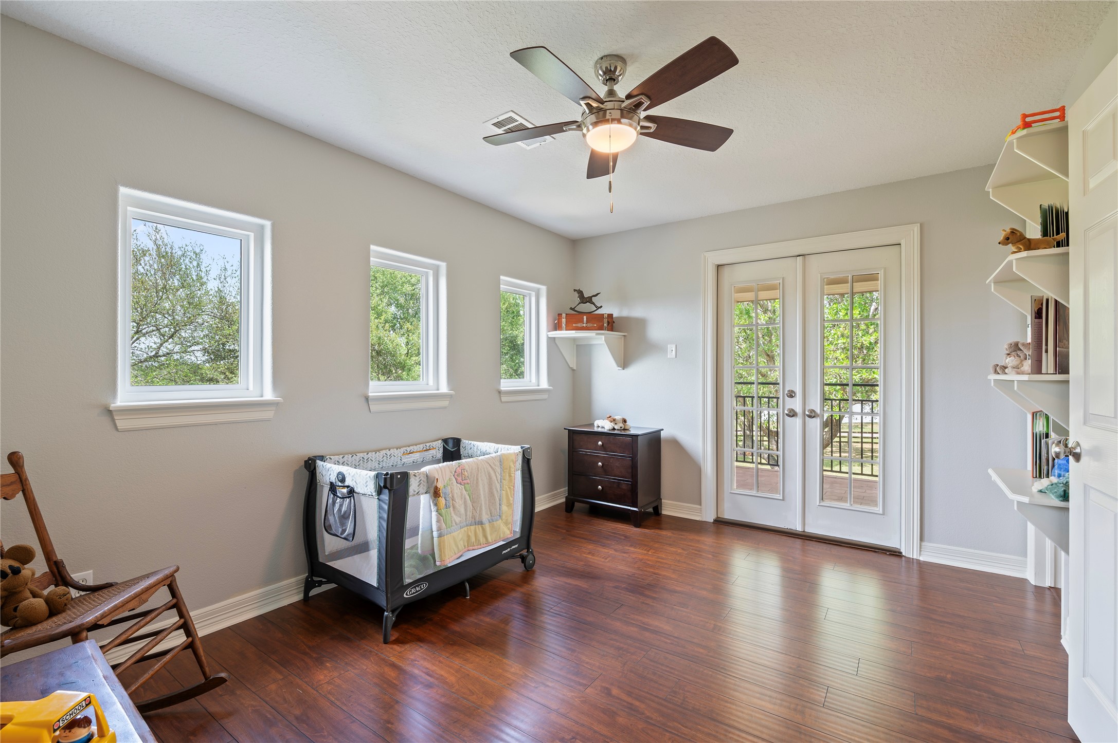 8211 Deats Lane Dickinson, TX 77539 - Photo 38 of 50 Bedroom 3 features a large walk-in closet, custom storage shelves, fresh paint in 2026 and hardwood floors. It's thoughtfully designed to capture breathtaking views of the property and offers direct access to the exterior balcony.