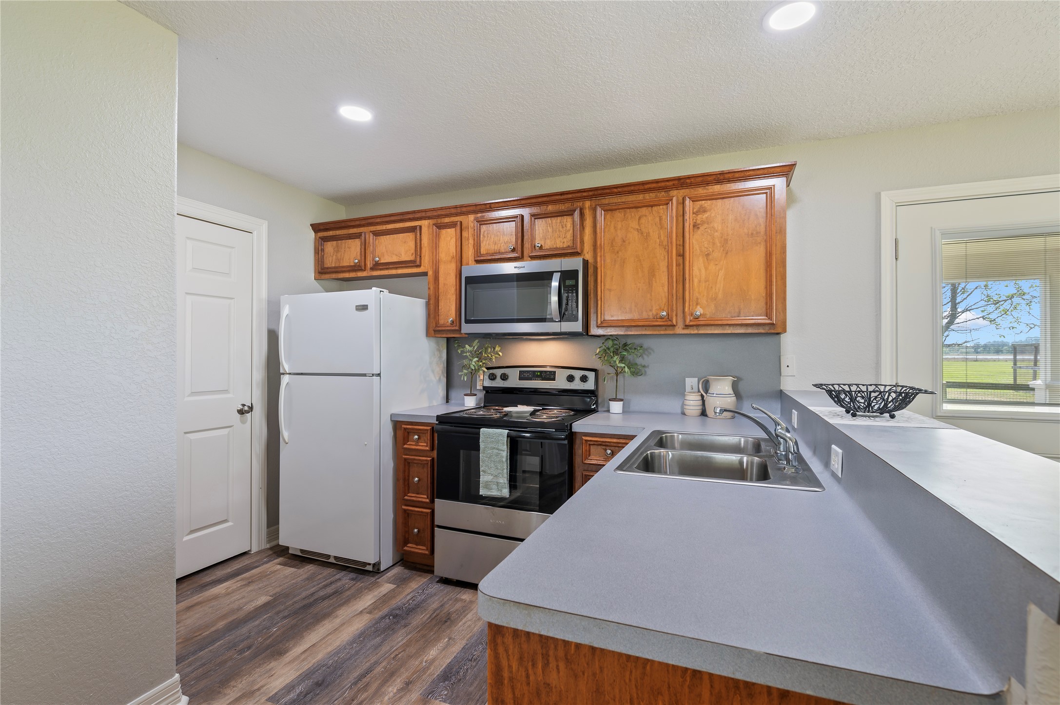 8211 Deats Lane Dickinson, TX 77539 - Photo 46 of 50 a kitchen with granite countertop a stove top oven a sink dishwasher a refrigerator and cabinets with wooden floor
