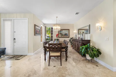a kitchen with stainless steel appliances a stove top oven a sink a counter top space and living room view