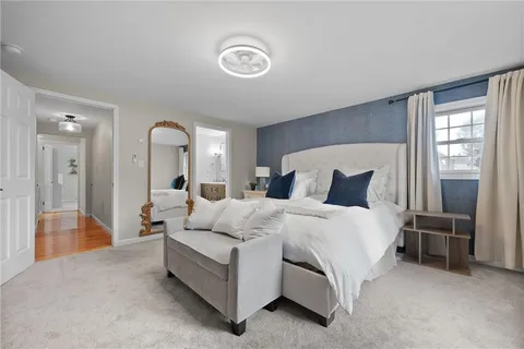 a spacious bedroom with a bed and a flat screen tv