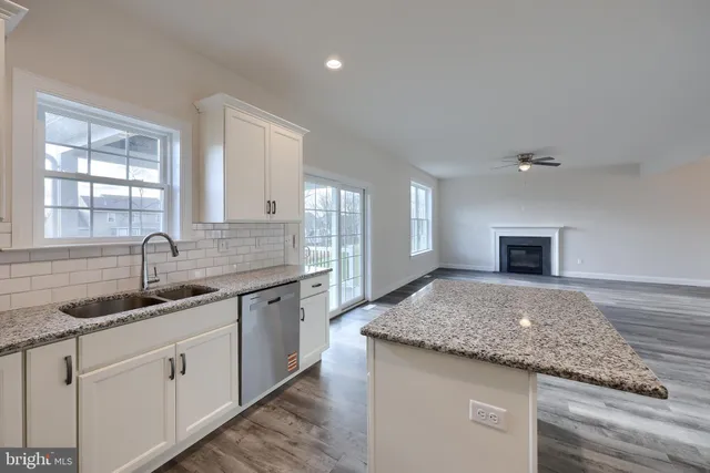 a en suite bathroom with a granite countertop sink and a large mirror