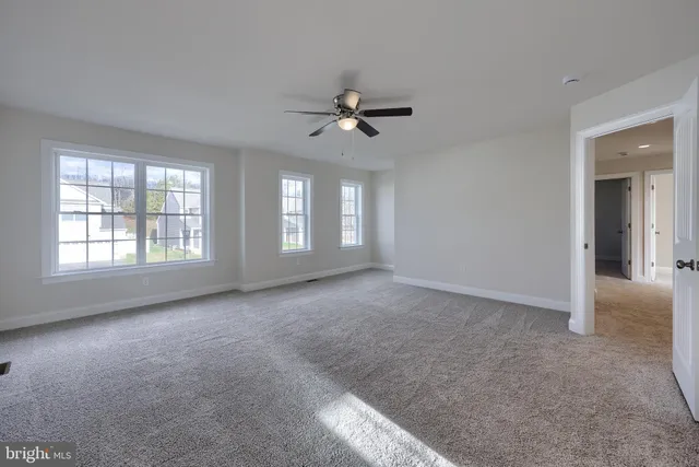 a view of a big room with windows and chandelier fan