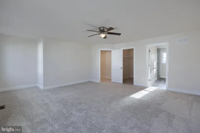 a view of a big room with chandelier fan and windows