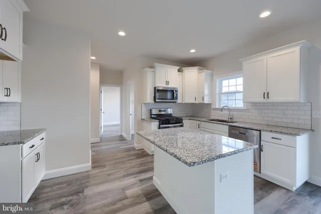 a kitchen with granite countertop a sink stove and refrigerator