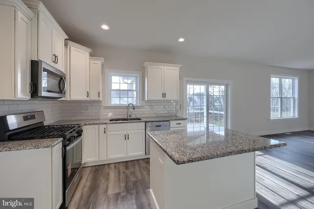a kitchen with stainless steel appliances granite countertop a sink stove and microwave