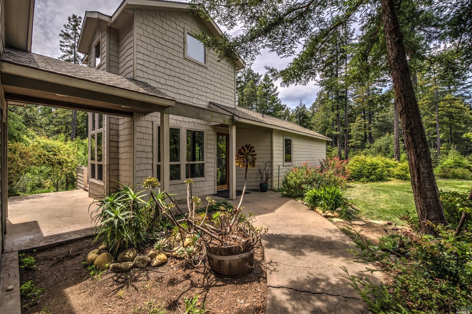 33604 Iversen Road Gualala, CA 95445 - Photo 1 of 1 a front view of a house with a garden and plants