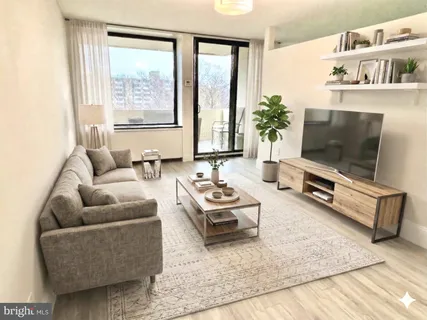 a living room with furniture flat screen tv and a large window