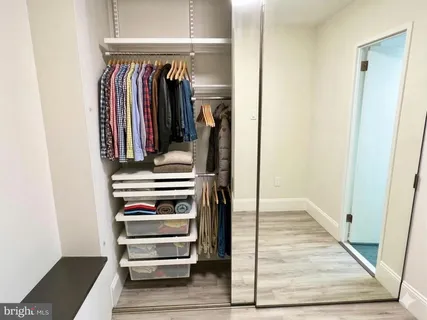 a view of walk in closet with clothes and shoes