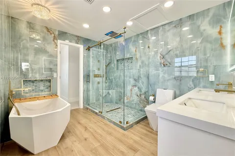 a bathroom with a tub a shower and sink