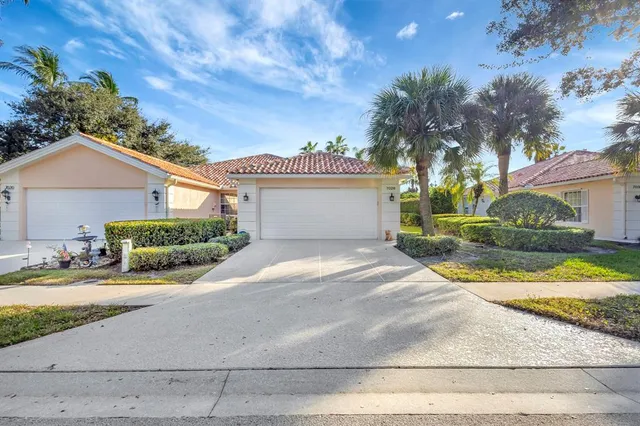 a view of a house with a yard and potted plants