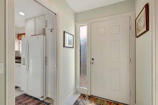 a kitchen view with stainless steel appliances kitchen island granite countertop a stove a sink a refrigerator and a dining table with chairs