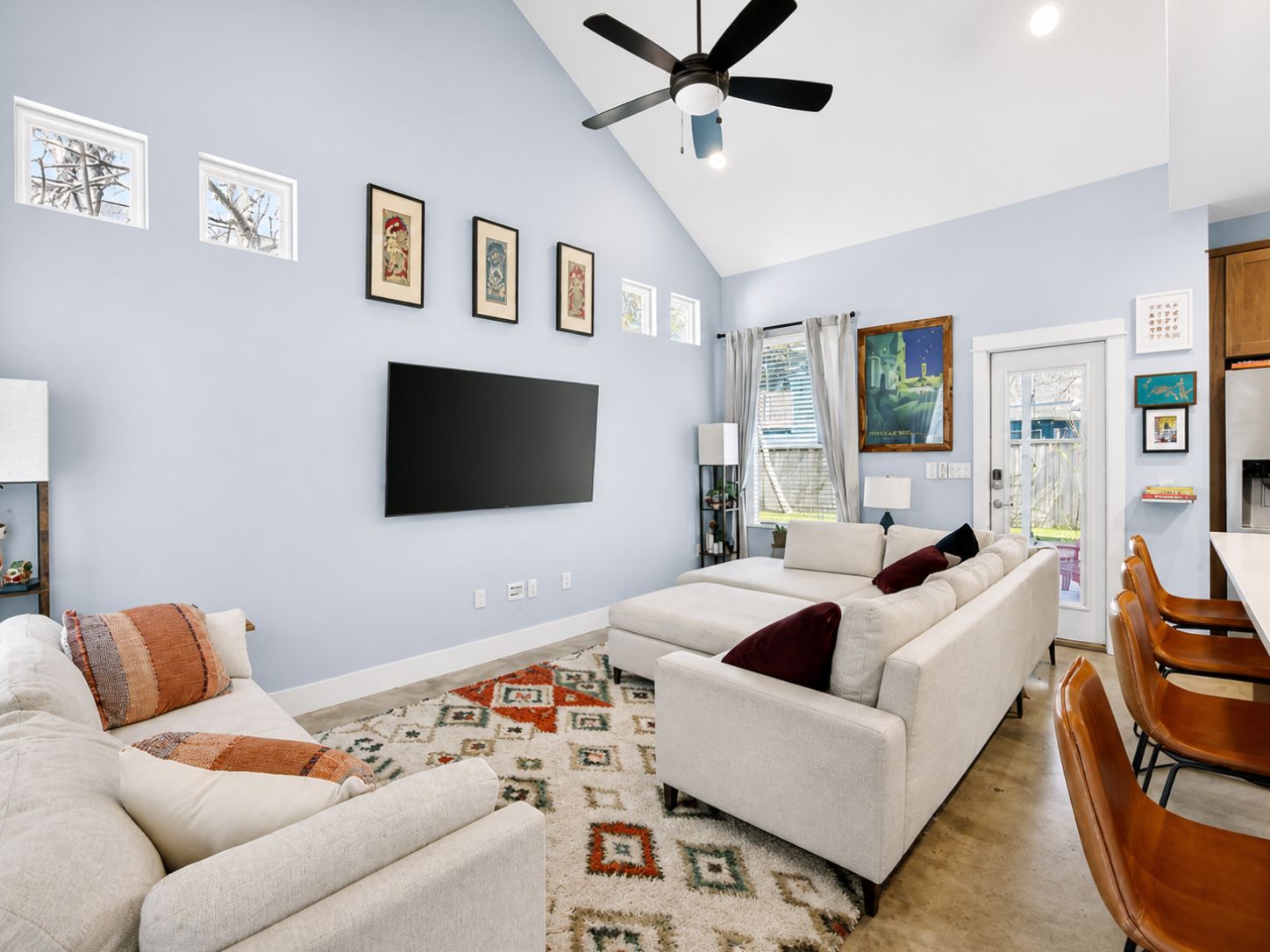 4917 Sunset Trail, Unit A Austin, TX 78745 - Photo 2 of 35 Vaulted ceiling with a ceiling fan, multiple wall-mounted windows, recessed lighting, concrete flooring, and a glass-paneled door