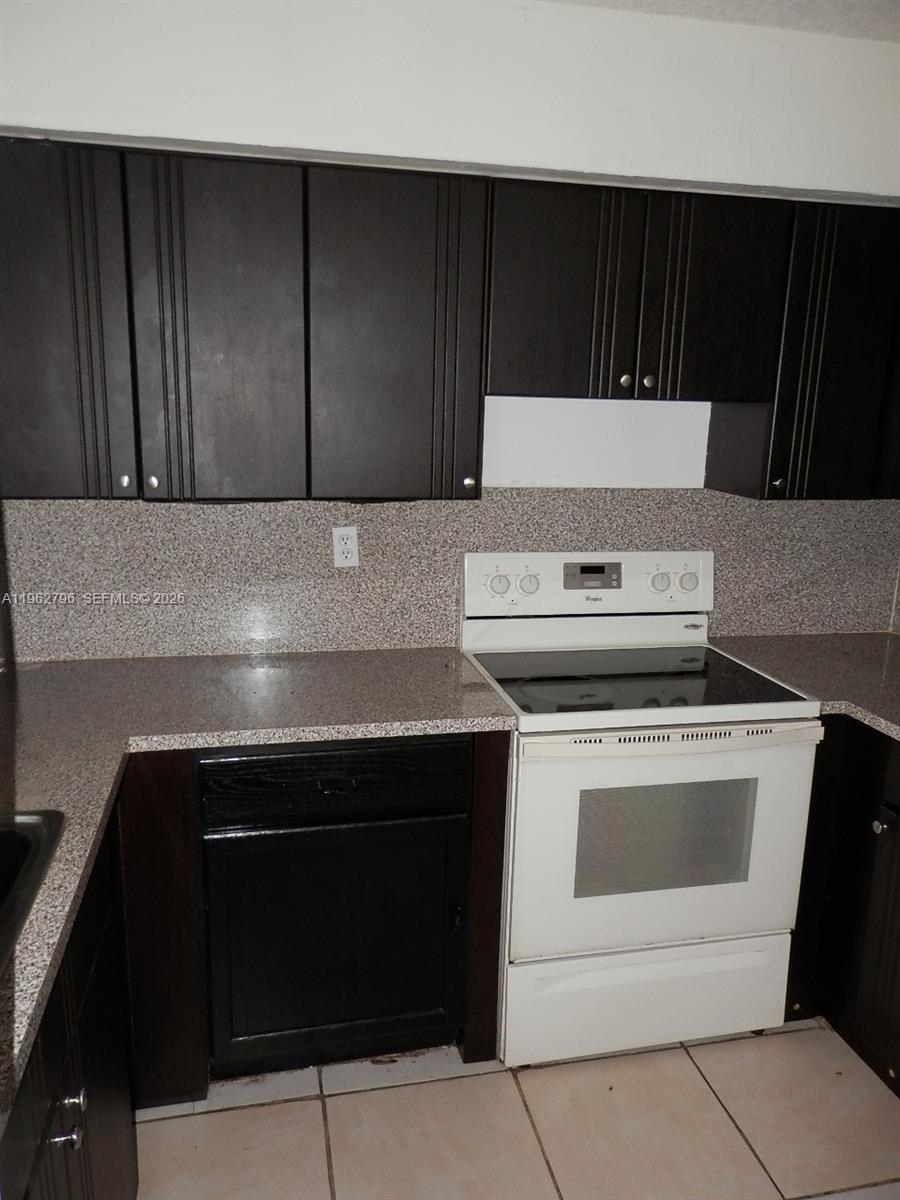 8365 Southwest 152nd Avenue, Unit C116 Miami, FL 33193 - Photo 2 of 8 a kitchen with a stove and a microwave
