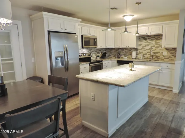 a kitchen with stainless steel appliances granite countertop a sink a stove and refrigerator