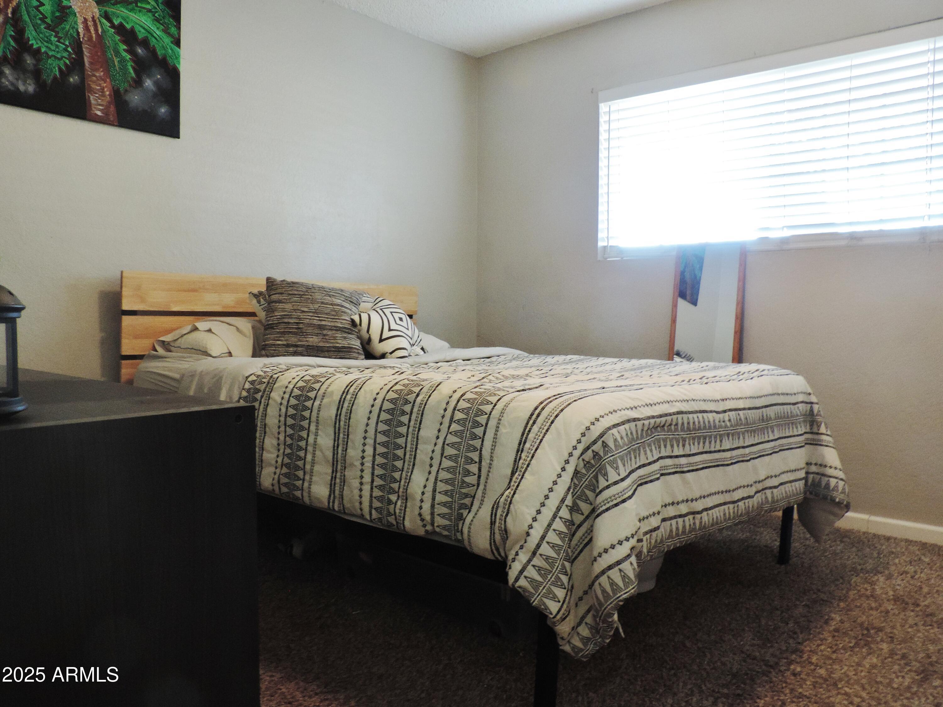764 North Thunderbird Drive Apache Junction, AZ 85120 - Photo 27 of 74 a bedroom with a bed and window