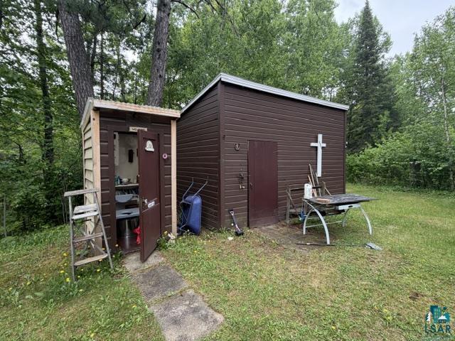 9064 Peppard Road Britt, MN 55710 - Photo 22 of 40 Two brown sheds with horizontal siding, one featuring a single door and a small window, the other a larger structure with a single door