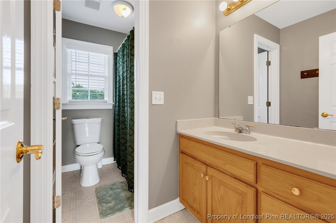 5247 Old Stage Road North Angier, NC 27501 - Photo 23 of 42 a bathroom with a granite countertop toilet sink and mirror
