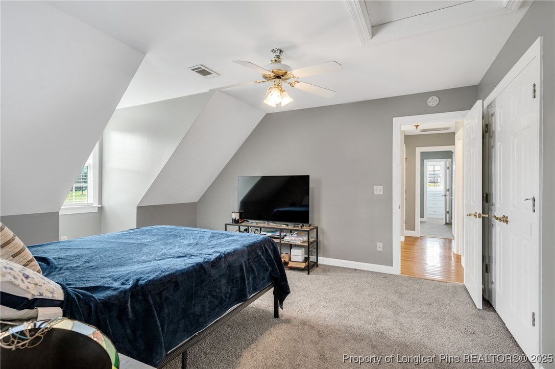 5247 Old Stage Road North Angier, NC 27501 - Photo 25 of 42 a bedroom with a bed and a chandelier