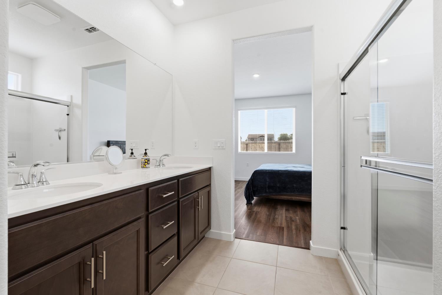 5713 Natalie Way Keyes, CA 95328 - Photo 12 of 30 a en suite bathroom with a double vanity sink a mirror and a shower