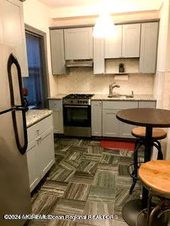 a kitchen with stainless steel appliances granite countertop a stove a sink and a microwave