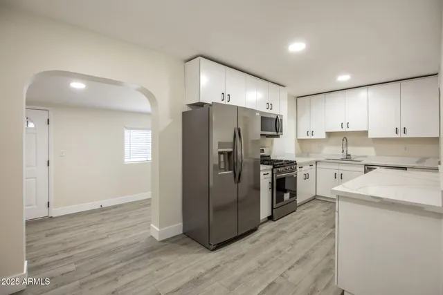 a kitchen with stainless steel appliances a refrigerator and a stove top oven