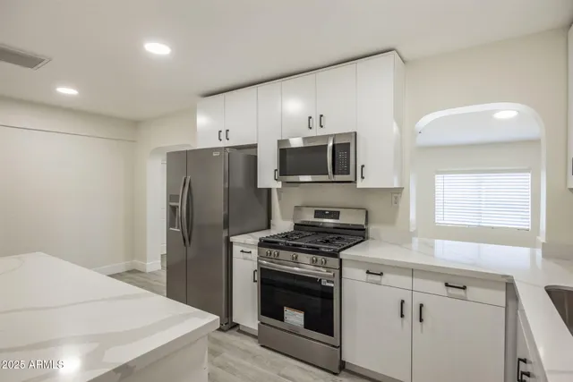 a kitchen with stainless steel appliances a refrigerator microwave and stove