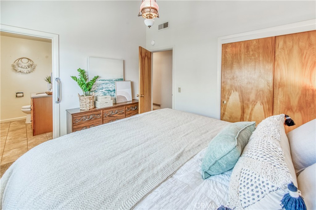 8 Ocean Front Lane, Unit AB Cayucos, CA 93430 - Photo 22 of 36 a bedroom with a large bed and a potted plant