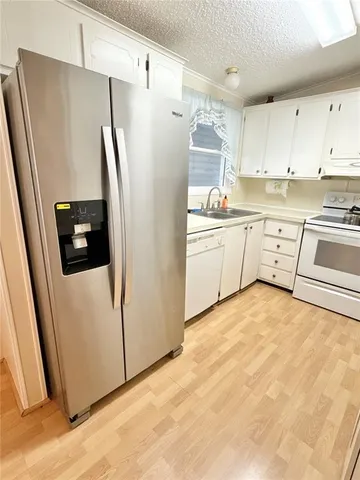 a kitchen with white cabinets and white stainless steel appliances