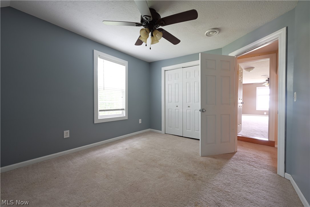 19105 Whitehead Road Lagrange, OH 44050 - Photo 32 of 37 Unfurnished bedroom featuring carpet flooring, a textured ceiling, a closet, and ceiling fan
