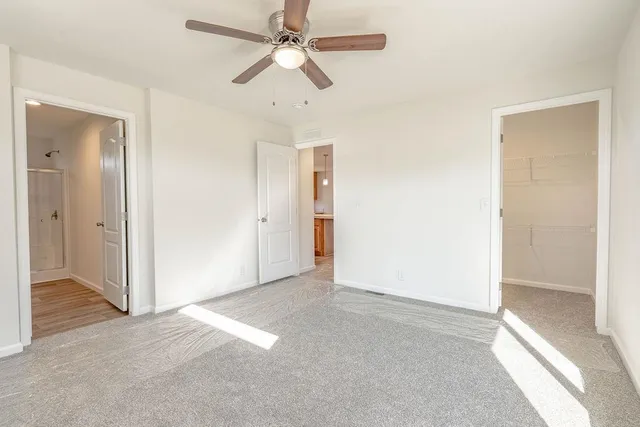 an empty room with a window and a ceiling fan