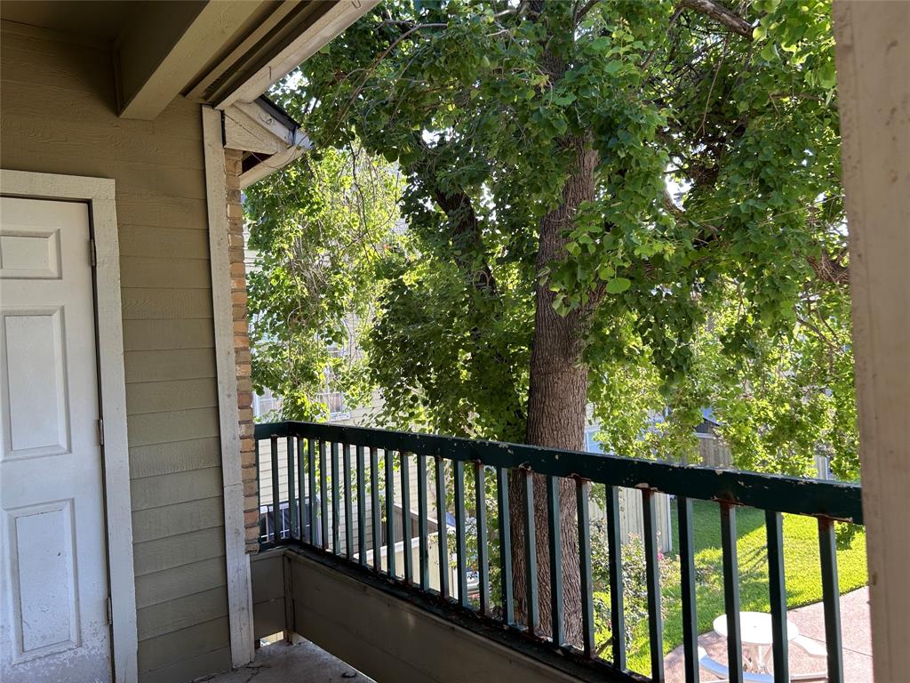 4107 Esters Road Irving, TX 75038 - Photo 1 of 21 Private balcony with dark green railing and a large, mature tree providing natural shade