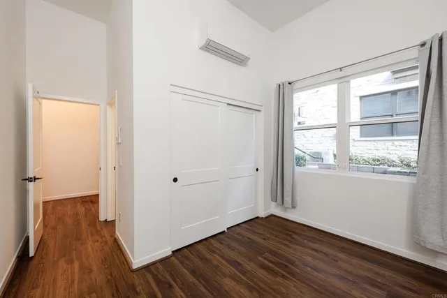 an empty room with windows and ceiling fan