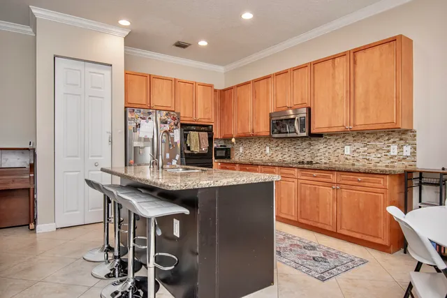 a kitchen with stainless steel appliances granite countertop a stove top oven a sink and cabinets