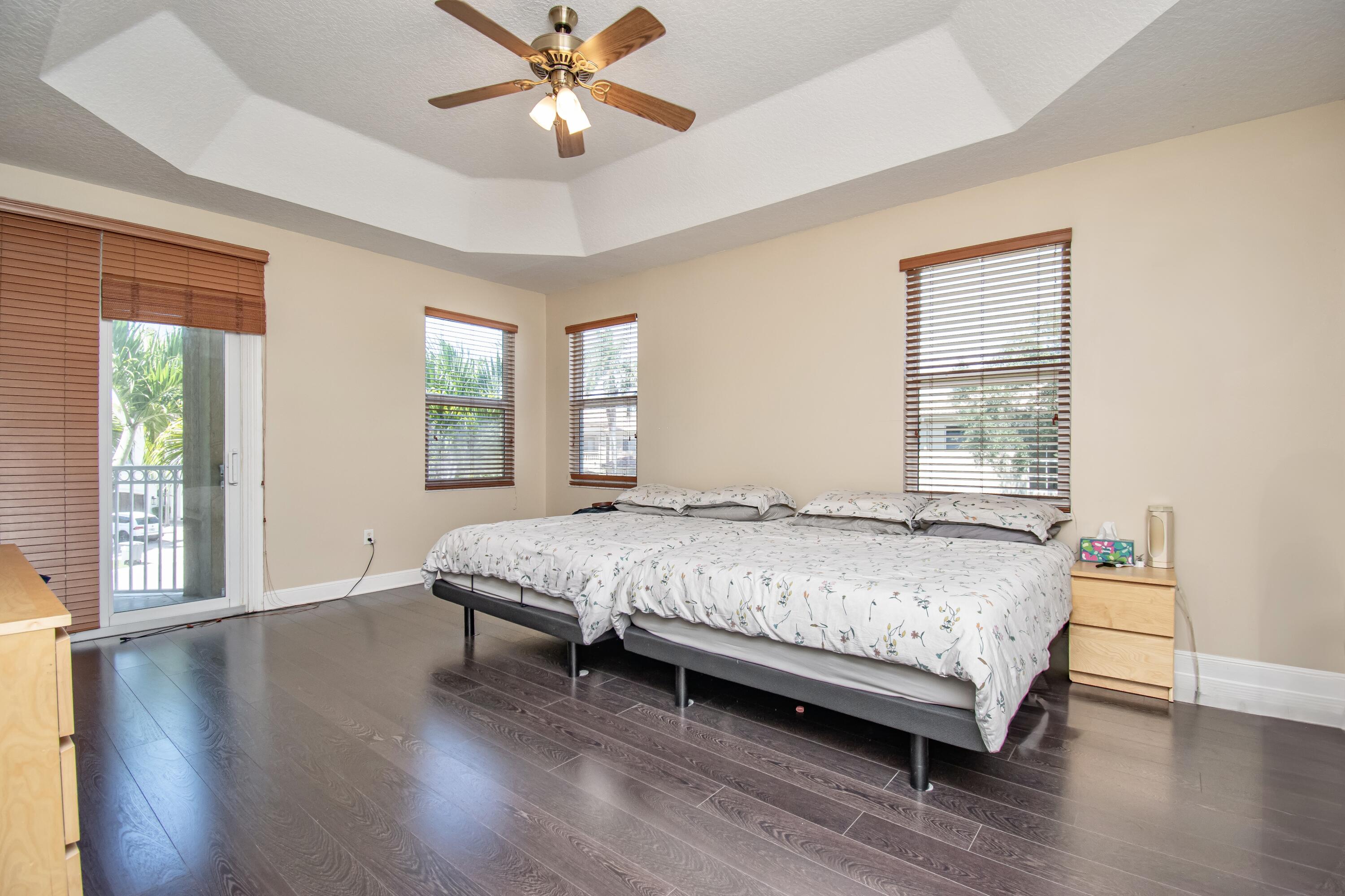9851 Palma Vista Way Boca Raton, FL 33428 - Photo 20 of 33 a bedroom with a bed and a large window with wooden floor