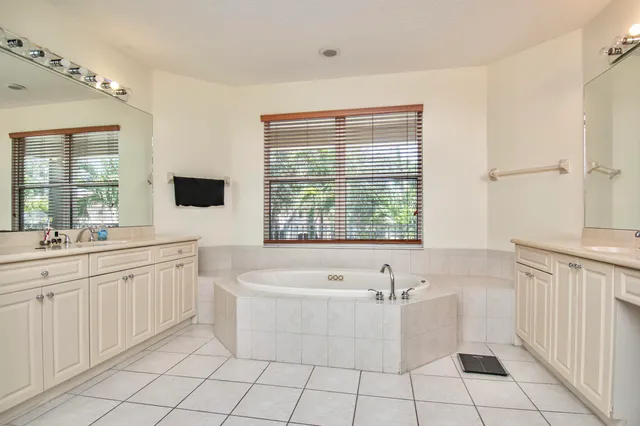 a bathroom with a bathtub a sink a mirror and a shower