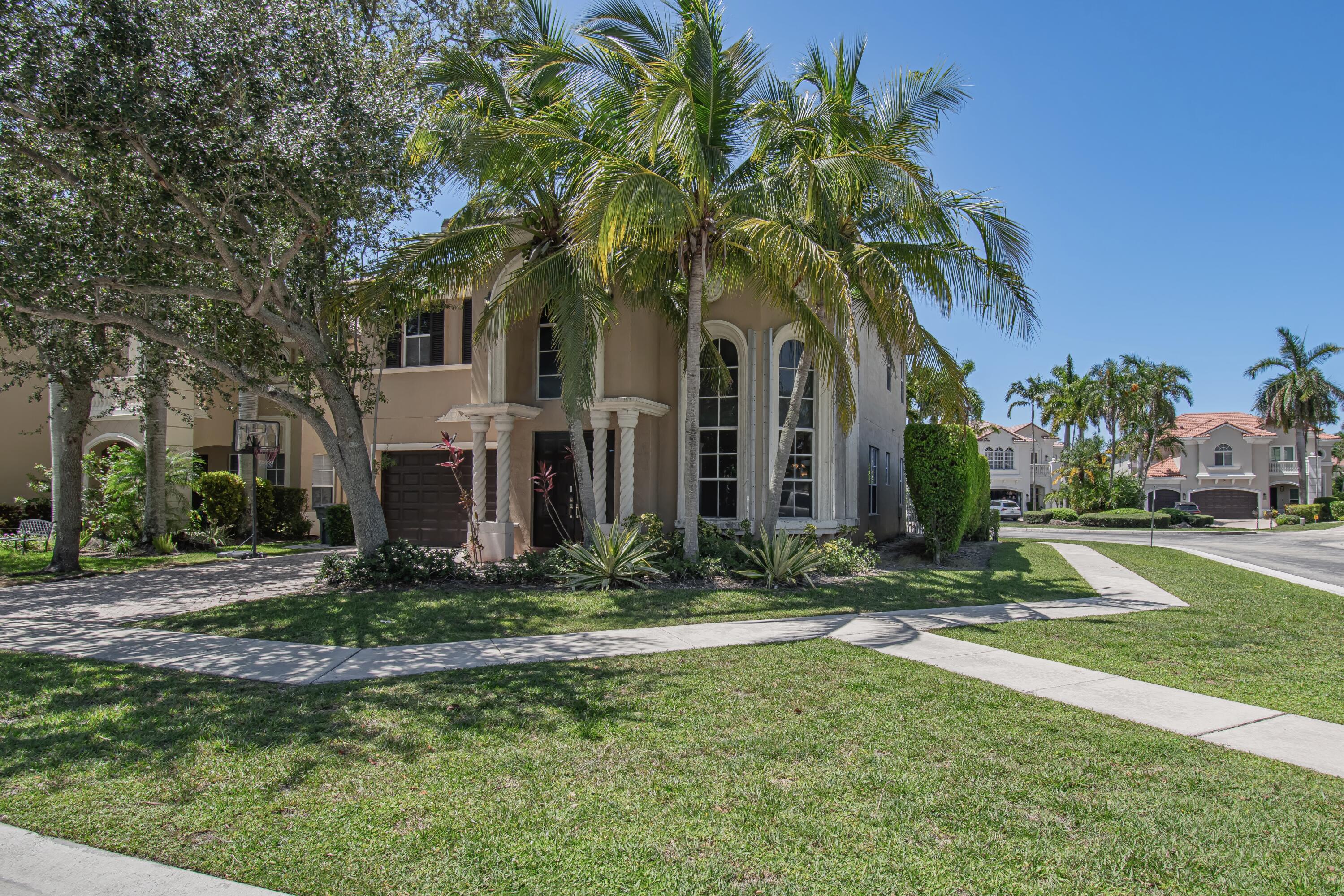 9851 Palma Vista Way Boca Raton, FL 33428 - Photo 3 of 33 a front view of a house with garden and trees