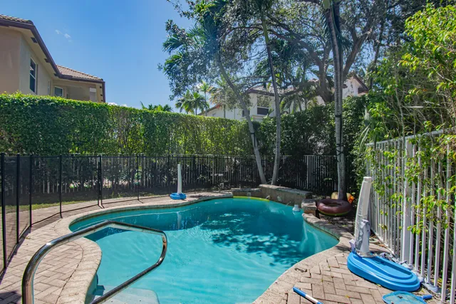a view of a backyard with couches potted plants and wooden fence