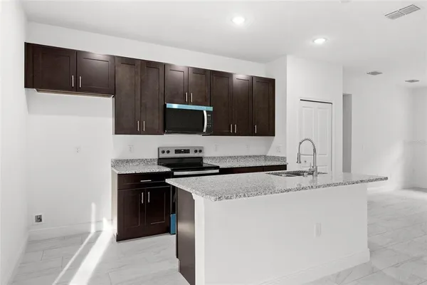 a kitchen with stainless steel appliances granite countertop a sink stove and refrigerator