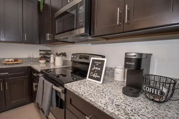 a kitchen with stainless steel appliances granite countertop a sink stove and cabinets