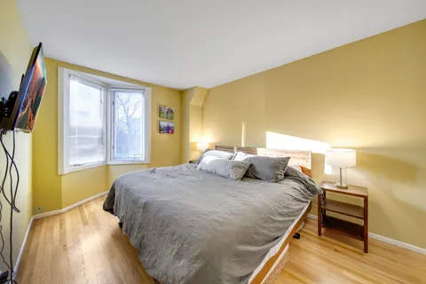 a bedroom with a bed and wooden floor
