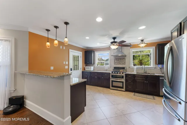a large kitchen with stainless steel appliances granite countertop a stove and a sink