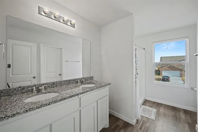a bathroom with a granite countertop sink a mirror and a toilet