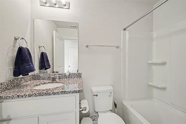 a bathroom with a sink toilet vanity and shower