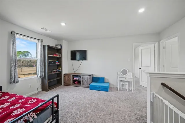 a living room with furniture a flat screen tv and a bookshelf