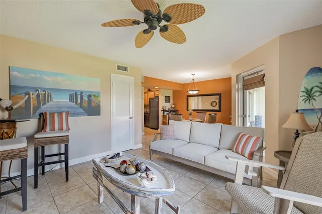 a living room with furniture kitchen view and a chandelier